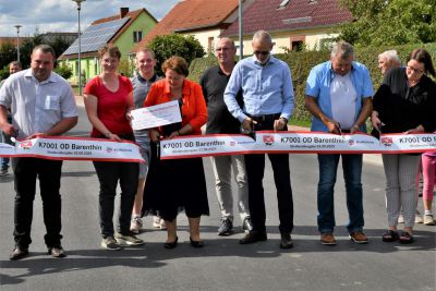 Zur Freigabe der Straße wurde das obligatorische rot-weiße Band durchtrennt. Foto: Bernd Atzenroth / Landkreis Prignitz 