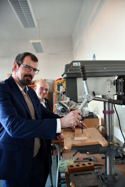 Bildungsminister Steffen Freiberg (vorne) probierte sich im Beisein von Landrat Christian Müller an der Werkbank aus.  Foto: Bernd Atzenroth / Landkreis Prignitz