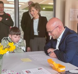 Bei einem Rundgang ließ es sich Landrat Christian Müller nicht nehmen, selbst einmal am Tisch Platz zu nehmen und sich beim „Schnell-Lesen“ auszuprobieren. / Foto: LK Prignitz, Gina Werthe